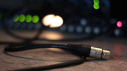 selective focus photography of black microphone cable on brown wooden surface thumbnail