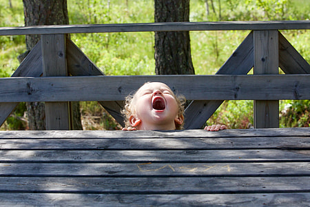 boy standing near gray wooden table at daytime thumbnail