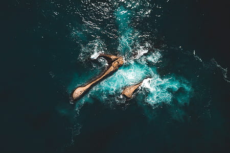aerial view photo of rock formation in the ocean thumbnail