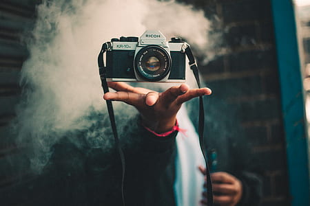 person holding black and silver DSLR camera thumbnail