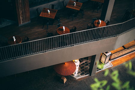 round and square brown wooden table on balcony thumbnail