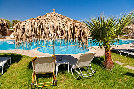 brown wicker patio umbrella infront of pool thumbnail