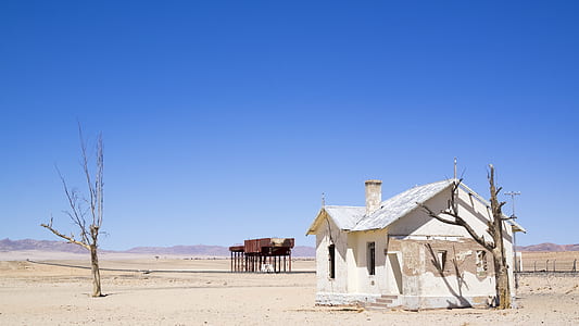 white house beside tree on sand thumbnail