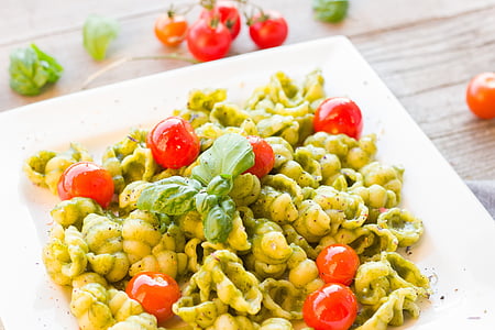 cooked pasta with cherry tomatoes and herb on white ceramic plate thumbnail