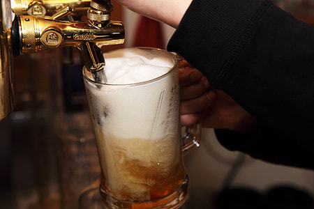 person filling clear glass mug with beer thumbnail