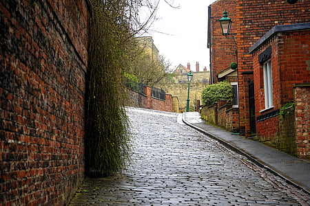 brown concrete road near concrete houses thumbnail