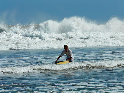 man surfboarding in sea during daytime thumbnail