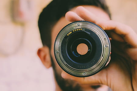 Selective Focus Photography of Man Holding Camera Lens thumbnail