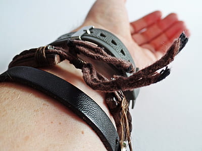 selective focus photography of person wearing brown leather adjustable bracelet and black watch thumbnail