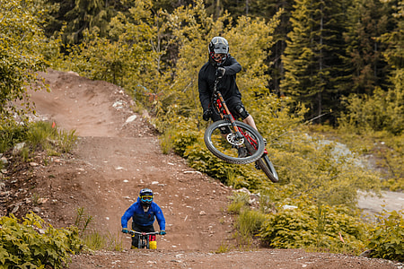 man riding on red full-suspension mountain bicycle during daytime thumbnail