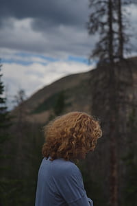 brown haired girl standing near trees thumbnail
