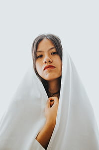 woman covering hear head with white scarf making face thumbnail