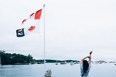 woman standing in front of flag on body of water thumbnail