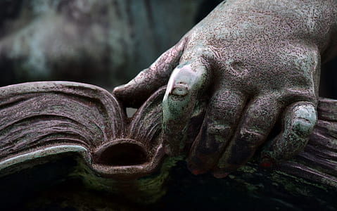 person holding book statue thumbnail