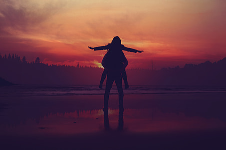 silhouette of man carrying a woman thumbnail