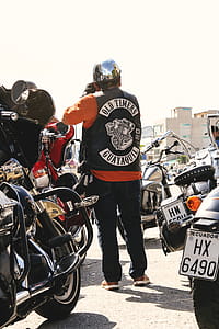 Man Standing Surrounded by Motorcycles thumbnail