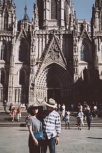 man holding woman's shoulder in front of gray concrete building during daytime thumbnail