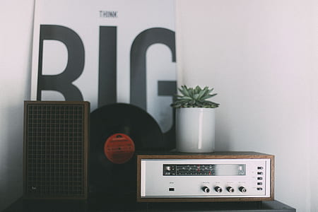 gray and brown audio component beside speaker and vinyl record on table thumbnail