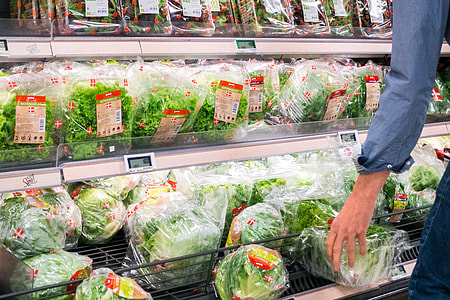 Woman picking lettuce in a grocery store thumbnail