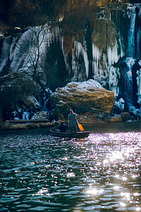 two person on boat near rock thumbnail