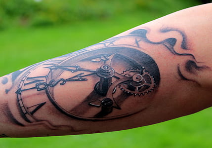 person showing analog clock tattoo at daytime thumbnail