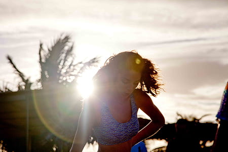 woman blue and white floral top under sun ray thumbnail