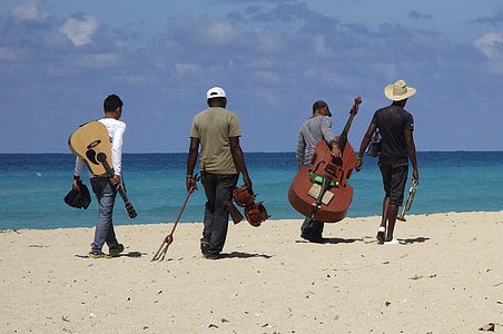 people carrying instruments on beach thumbnail