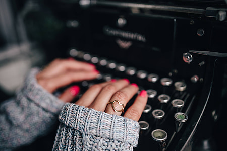 Woman typing on an old typewriter thumbnail