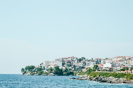 body of water near high-rise building under blue sky at daytime thumbnail
