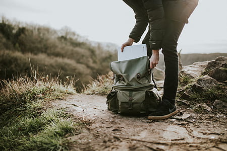 man holding black and gray backpack during datyime thumbnail