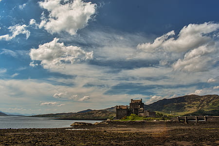 photo of castle on mountain near body of water thumbnail