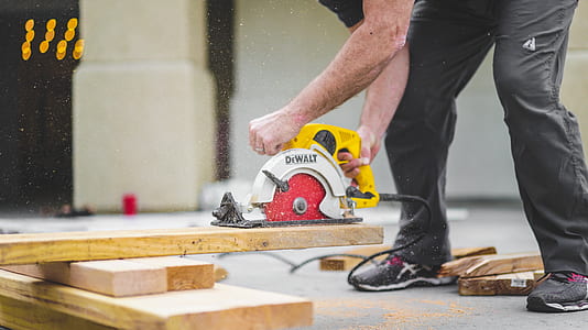 man using yellow and white DeWalat circular saw thumbnail
