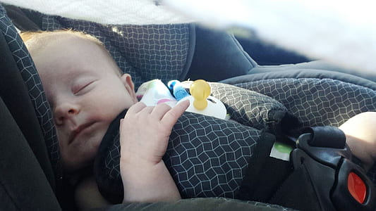 baby sleeping on grey vehicle booster seat thumbnail