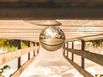 Macro Photography of Round Glass Ball on Top of Brown Wooden Dock thumbnail