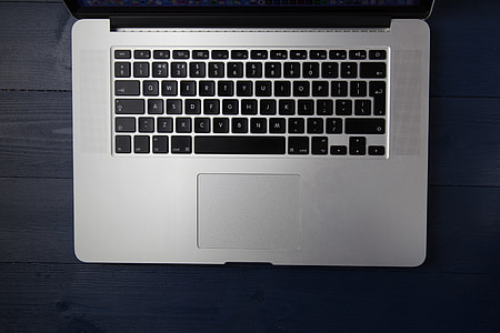 Apple laptop computer on a blue wood desk thumbnail