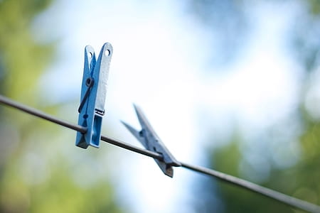 selective focus photography of blue clothes clips on black wires thumbnail