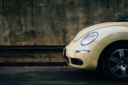 yellow Volkswagen New Beetle parked on side of street thumbnail