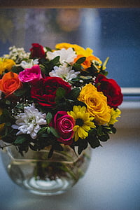 assorted-color flowers on clear glass vase centerpiece close-up photo thumbnail