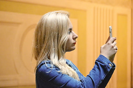 woman holding smartphone taken on lighted room thumbnail