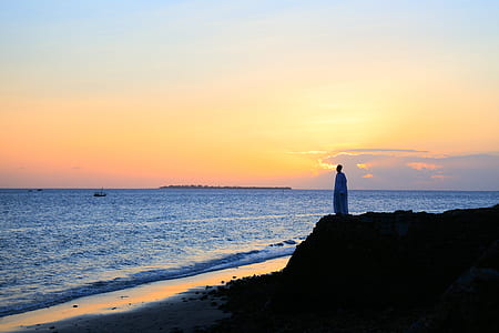 person standing near ocean during golden hour thumbnail
