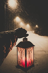 person holding candle lantern thumbnail