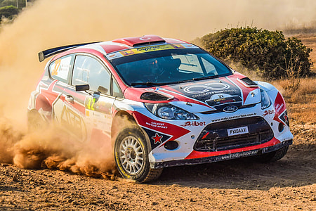 white, red, and black Ford Focus Rally car on sandy area thumbnail