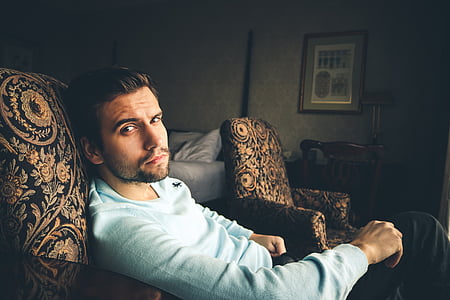 men's white sweater sitting on brown and black floral armchair thumbnail