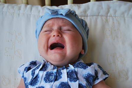 baby wearing white and blue floral top and hat thumbnail
