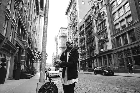 grayscale man standing near street post thumbnail