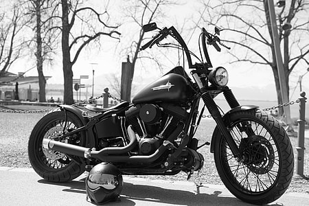 grayscale photography of cruiser motorcycle near helmet thumbnail