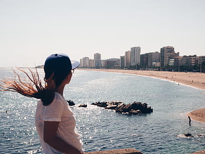 woman standing on cliff in front of sea thumbnail