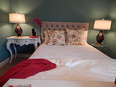 bed with red blanket on the side and table lamps turned on thumbnail