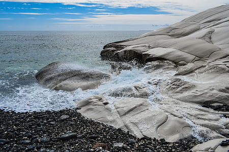 sea waves on rock formation under blue sky thumbnail