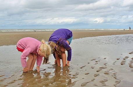 two woman stuck on brown sand beach thumbnail